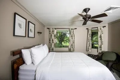 a bedroom with a white bed with a ceiling fan at Cozy getaway w/pool-tennis-bbq near Manuel Antonio in Manuel Antonio