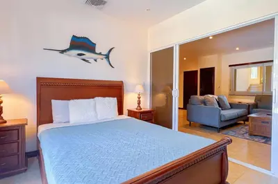 a bedroom with a bed and a living room at Condo Las Brisas near to Marina Herradura, free Pool and wifi in Herradura