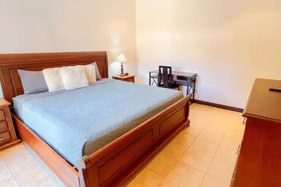 a bedroom with a bed and a desk with a night stand at Condo Las Brisas near to Marina Herradura, free Pool and wifi in Herradura