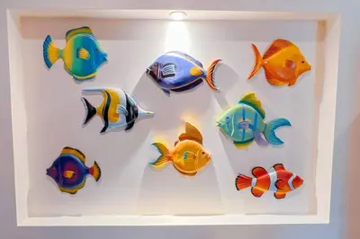 a group of colorful fish hanging on a wall at Condo Las Brisas near to Marina Herradura, free Pool and wifi in Herradura