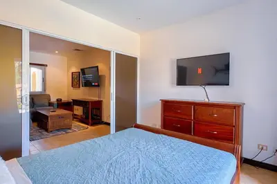 a bedroom with a bed and a dresser with a flat screen tv at Condo Las Brisas near to Marina Herradura, free Pool and wifi in Herradura