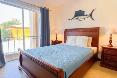 a bedroom with a bed with a fish on the wall at Condo Las Brisas near to Marina Herradura, free Pool and wifi in Herradura