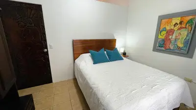 a bedroom with a bed with blue pillows on it at Casa Bambu céntrico, lindo y acogedor con A C in General Viejo