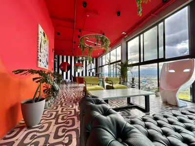 a room with red walls and a table and chairs at COZY STUDIO near SABANA CENTRAL PARK in San José