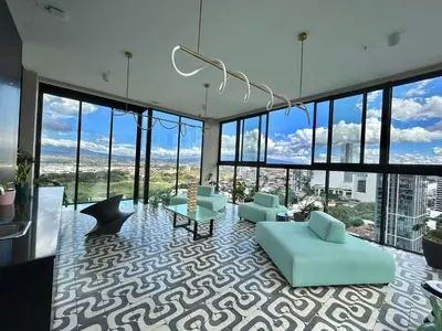 a living room with a lot of windows at COZY STUDIO near SABANA CENTRAL PARK in San José