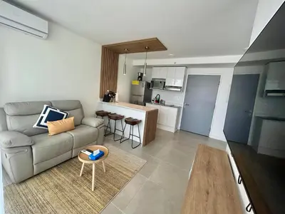 a living room with a couch and a kitchen at COZY STUDIO near SABANA CENTRAL PARK in San José