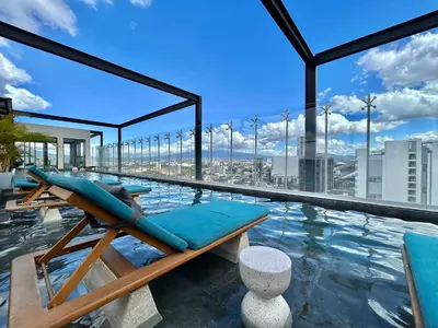 a pool with a lounge chair on the roof of a building at COZY STUDIO near SABANA CENTRAL PARK in San José