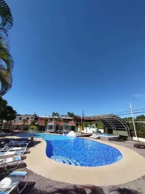 a large swimming pool with lounge chairs around it at Casa Yorba in Jacó