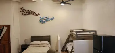 a room with two bunk beds and a ceiling fan at Casa Yorba in Jacó