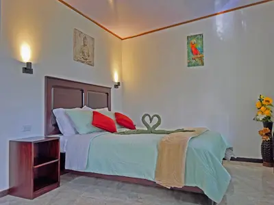 a bedroom with a bed with red and green pillows at Monteverde Magic Mountain in Monteverde Costa Rica