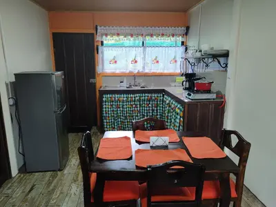 a kitchen with a table with chairs and a refrigerator at The Bees House in Fortuna