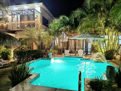 a swimming pool in front of a house at night at Suite Dream Blue in Tamarindo