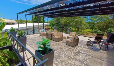 a patio with couches and chairs under a pergola at Suite Dream Blue in Tamarindo