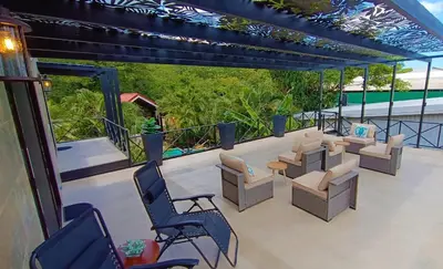 a patio with chairs and tables on a balcony at Suite Dream Blue in Tamarindo