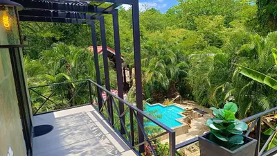 a view of a pool from the balcony of a house at Suite La Orquidea in Tamarindo
