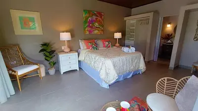 a bedroom with a bed and a table and chairs at Suite La Orquidea in Tamarindo