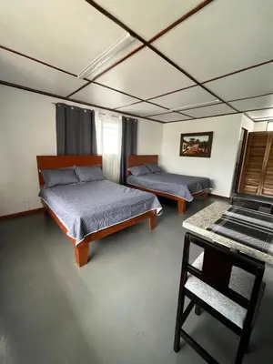 a room with two beds and a table in it at MARIO in Alajuela City