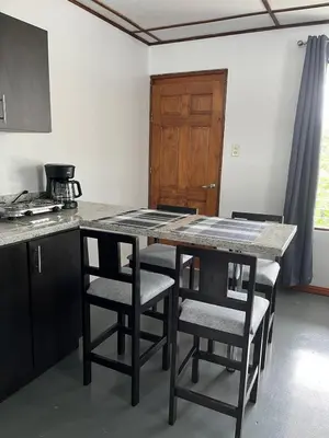a kitchen with a table with chairs and a counter top at MARIO in Alajuela City