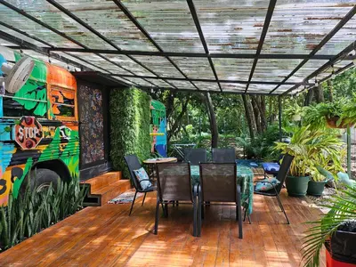 a patio with a table and chairs and a bus at CasaBus beautiful bus dept. 50m from beach in Santa Cruz