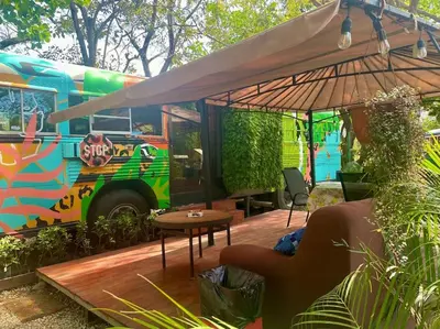 a colorful bus with a table and an umbrella at CasaBus beautiful bus dept. 50m from beach in Santa Cruz