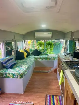 a camper with a couch in the middle of a room at CasaBus beautiful bus dept. 50m from beach in Santa Cruz