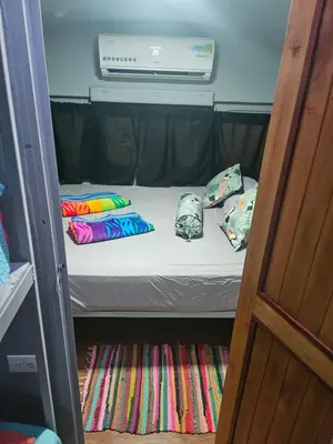 a small bed in a room with pillows on it at CasaBus beautiful bus dept. 50m from beach in Santa Cruz