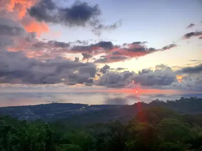 a sunset over a body of water with trees at The Garden Casitas by Vista Celestial in Uvita