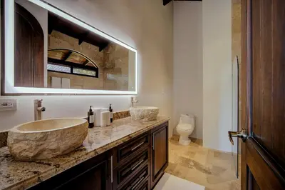 a bathroom with a large stone sink and a toilet at The Garden Casitas by Vista Celestial in Uvita