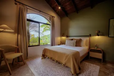 a bedroom with a bed and a large window at The Garden Casitas by Vista Celestial in Uvita