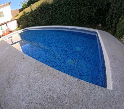 a blue swimming pool with blue tiles on the ground at Habitación Privada Economica con baño compartido in Brasilito