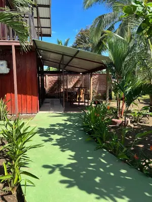 a patio with awning on the side of a building at Tortuguero Hill Rooms in Tortuguero