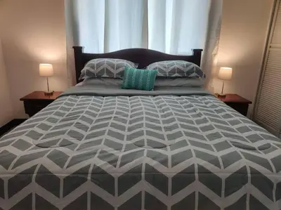 a bedroom with a large bed with two lamps at Condo en Jacó in Jacó