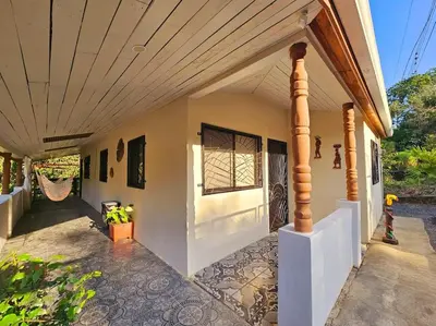 an outside view of a house with a porch at Casa Cariad Close to surfing lessons and more! in Parrita