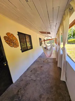 a train car with curtains and a hammock in it at Casa Cariad Close to surfing lessons and more! in Parrita