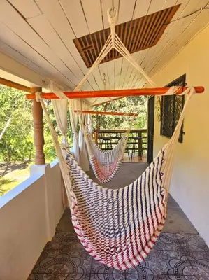 a hammock hanging on a porch in a house at Casa Cariad Close to surfing lessons and more! in Parrita