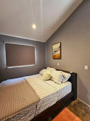 a small bedroom with a bed and avertisement at Casa Cariad Close to surfing lessons and more! in Parrita