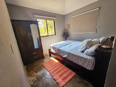 a bedroom with a bed and a window at Casa Cariad Close to surfing lessons and more! in Parrita