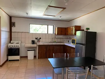 a kitchen with a black table and a refrigerator at Globi Lodge #5 in Monteverde Costa Rica
