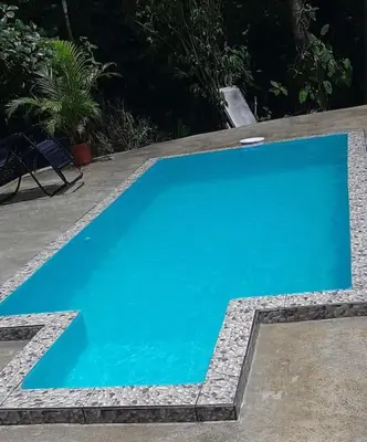 a blue swimming pool with a chair next to it at Casa Montaña & Spa Pital de San Carlos Costa Rica in Pital