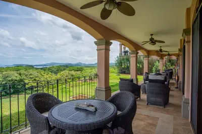 a patio with a table and chairs on a balcony at Spacious 2BR Condo with Ocean Glimpse - Jobo - Reserva Conchal Golf Resort in Playa Conchal
