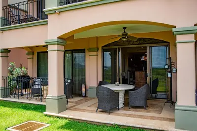 a patio with chairs and a table on a house at Spacious 2BR Condo with Ocean Glimpse - Jobo - Reserva Conchal Golf Resort in Playa Conchal