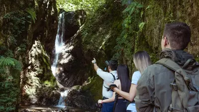 a group of people standing in front of a waterfall at Hacienda La Lucha in Lucha