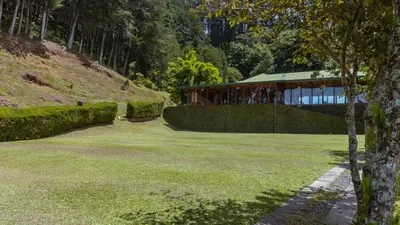 a building in the middle of a grassy yard at Hacienda La Lucha in Lucha