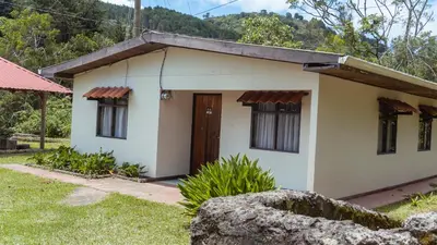 a small white house with a door in a yard at Hacienda La Lucha in Lucha