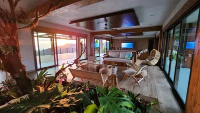 a living room with a couch and some plants at Lamangata Luxury Surf Resort in Dominical