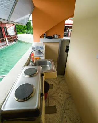 a small kitchen with a sink and a sink at Hostel de Haan in Jacó
