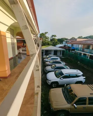 a row of cars parked outside of a building at Hostel de Haan in Jacó