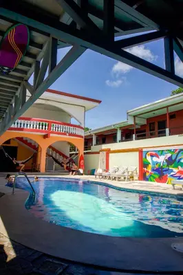 a large swimming pool in a building with a pool at Hostel de Haan in Jacó