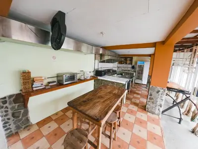a kitchen with a wooden table in a room at Hostel de Haan in Jacó