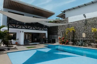 a swimming pool in front of a house at Private home with resort style swimming pool in Jacó
